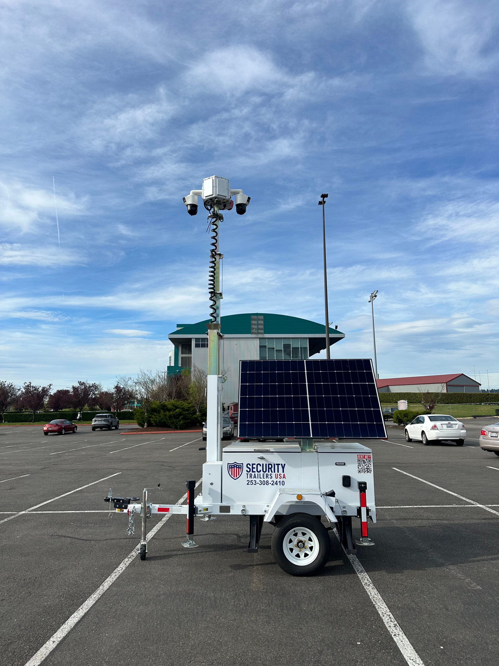 Mobile surveillance trailer positioned in parking lot for wide area monitoring